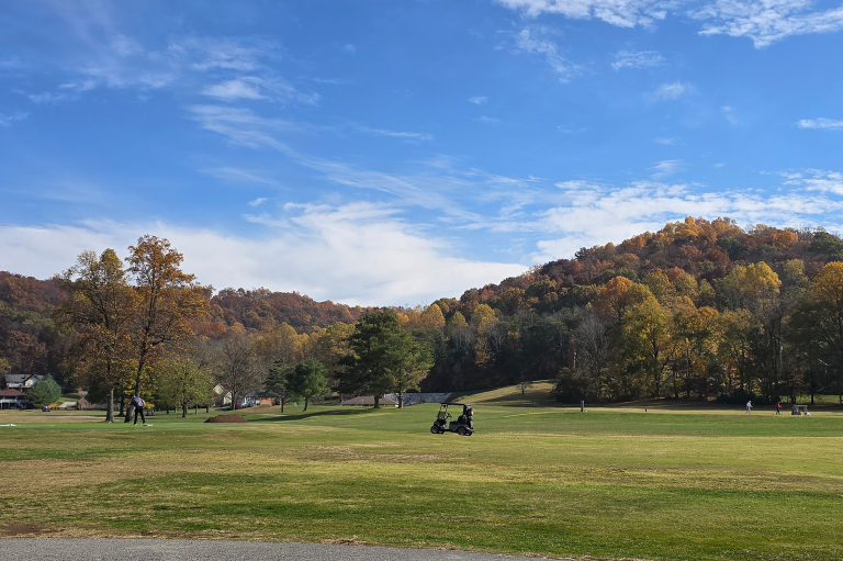 Golf cart on golf course with mountain range in distance